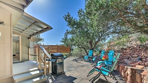 An outdoor patio with a grill, seating area, and a staircase leading to a covered entrance. - Sedona Stardust Hideaway' w/ Patio & Mtn Views! (Sedona)