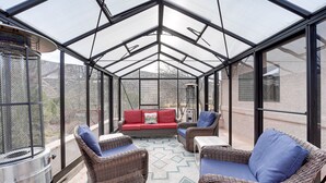 A sunroom with a glass ceiling, wicker furniture, and a red sofa. - Secluded Sedona Escape w/ Patio & Red Rock Views! (Sedona)