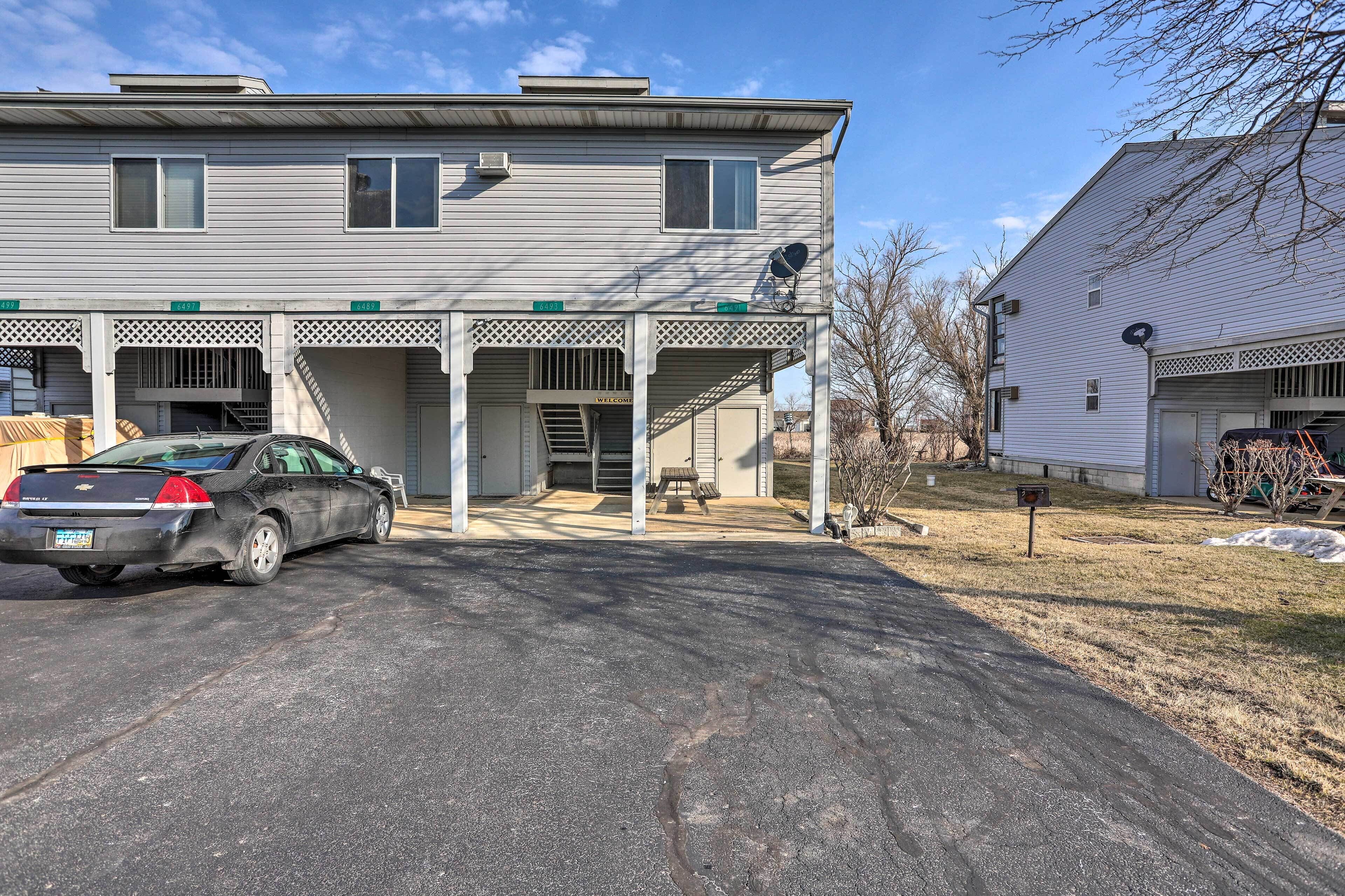 A two-story house with a covered front porch, a garage, and a satellite dish.