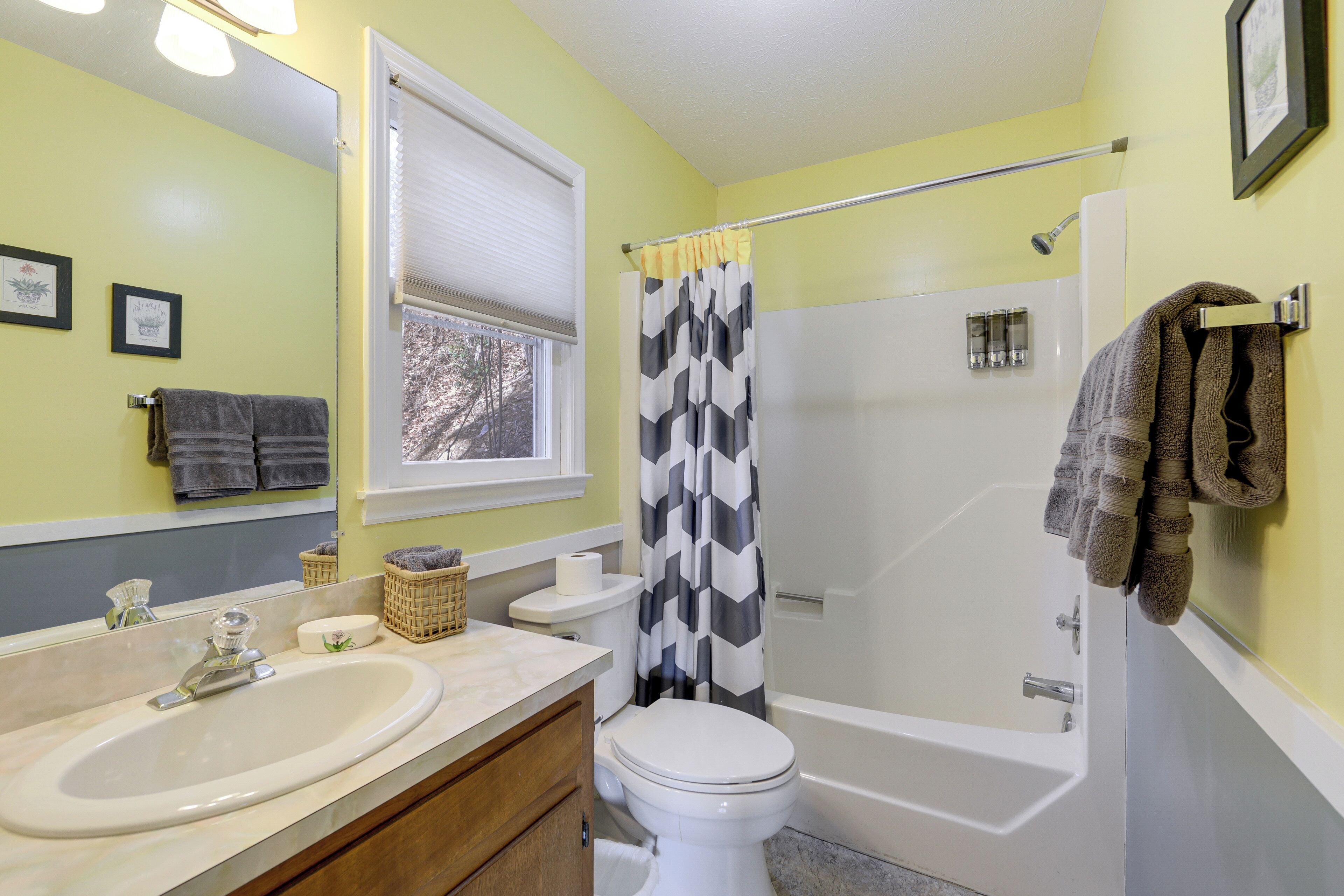 A bathroom with a sink, toilet, bathtub, and shower curtain.