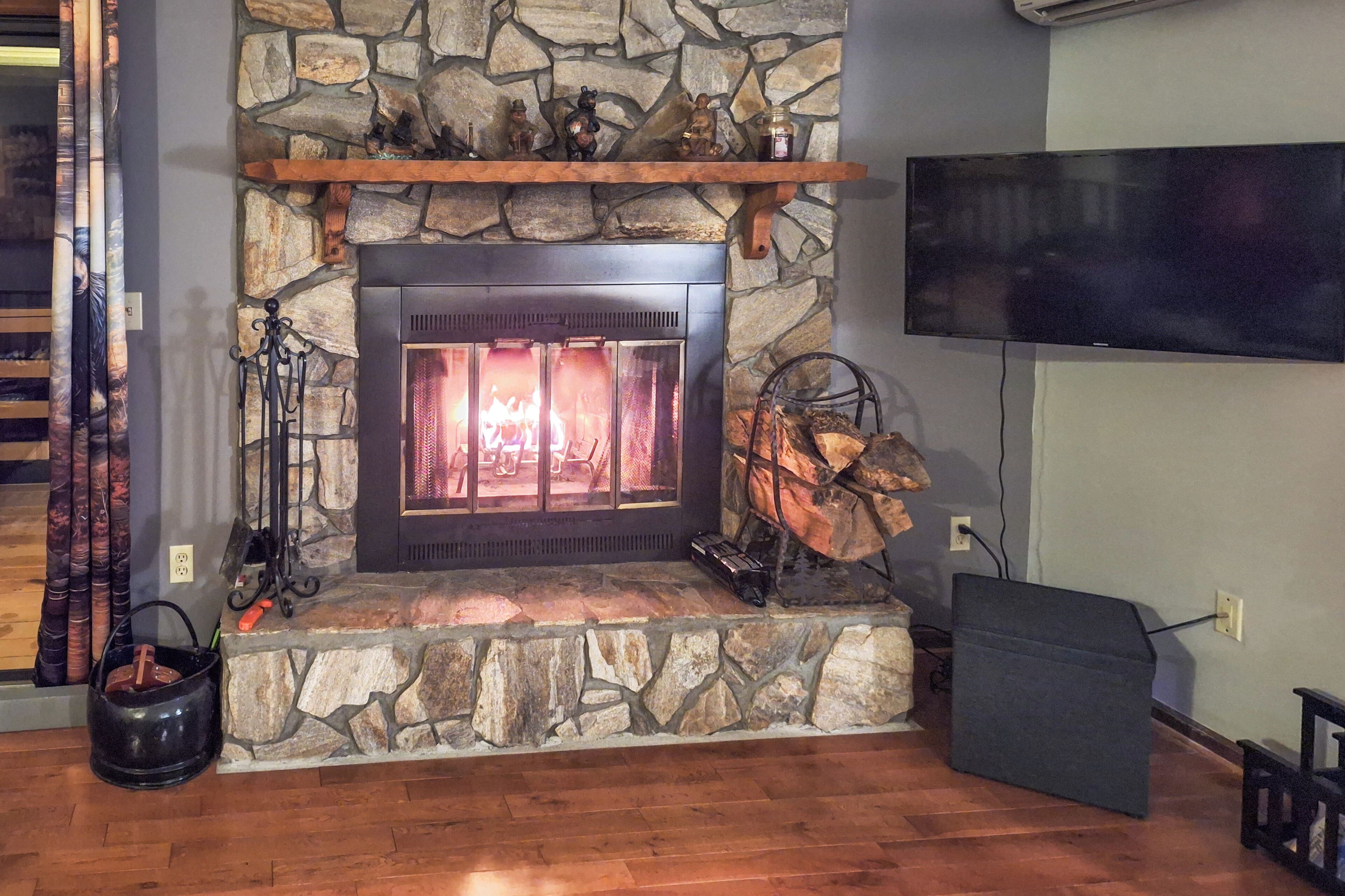 Una chimenea de piedra con un televisor montado en la pared superior.