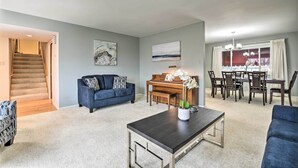 A living room with a piano, a dining table with chairs, a sofa, and a coffee table. - Spacious Family Glenwood Estates Home w/ Hot Tub! (Glenwood)