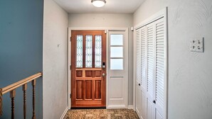 A hallway with a wooden door, a white door, and a white closet with louvered doors. - Spacious Family Glenwood Estates Home w/ Hot Tub! (Glenwood)