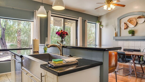 A modern kitchen with a large island, pendant lights, and a ceiling fan. - Pet-friendly Snowbird Haven w/ Pool in Gold Canyon (Gold Canyon)