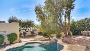 A swimming pool with a curved edge, surrounded by a patio area with a stone border and a seating table. - Pet-friendly Snowbird Haven w/ Pool in Gold Canyon (Gold Canyon)