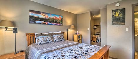 Un dormitorio con una cama de madera, dos mesitas de noche y una lámpara de pared.