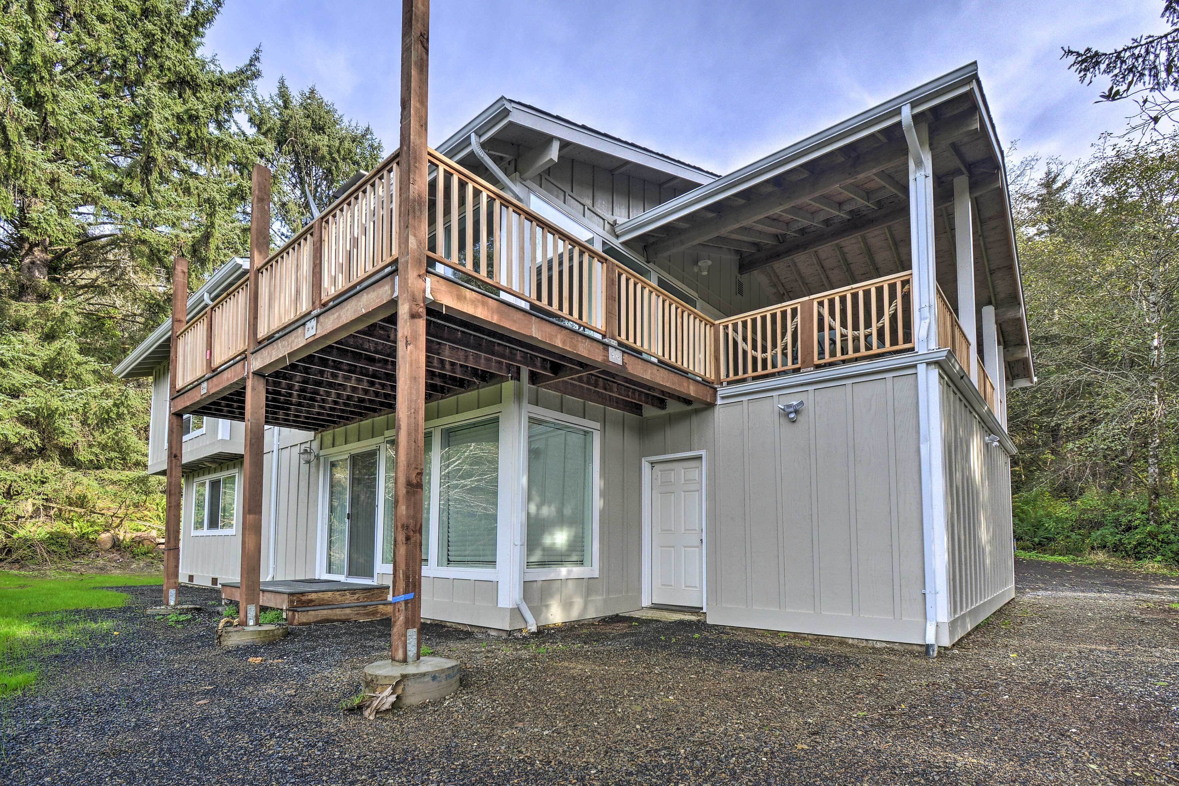 A two-story house with a wooden deck and a garage.