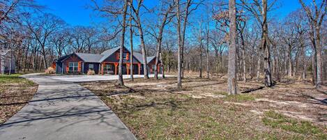 A modern house with a large driveway and a well-maintained lawn.
