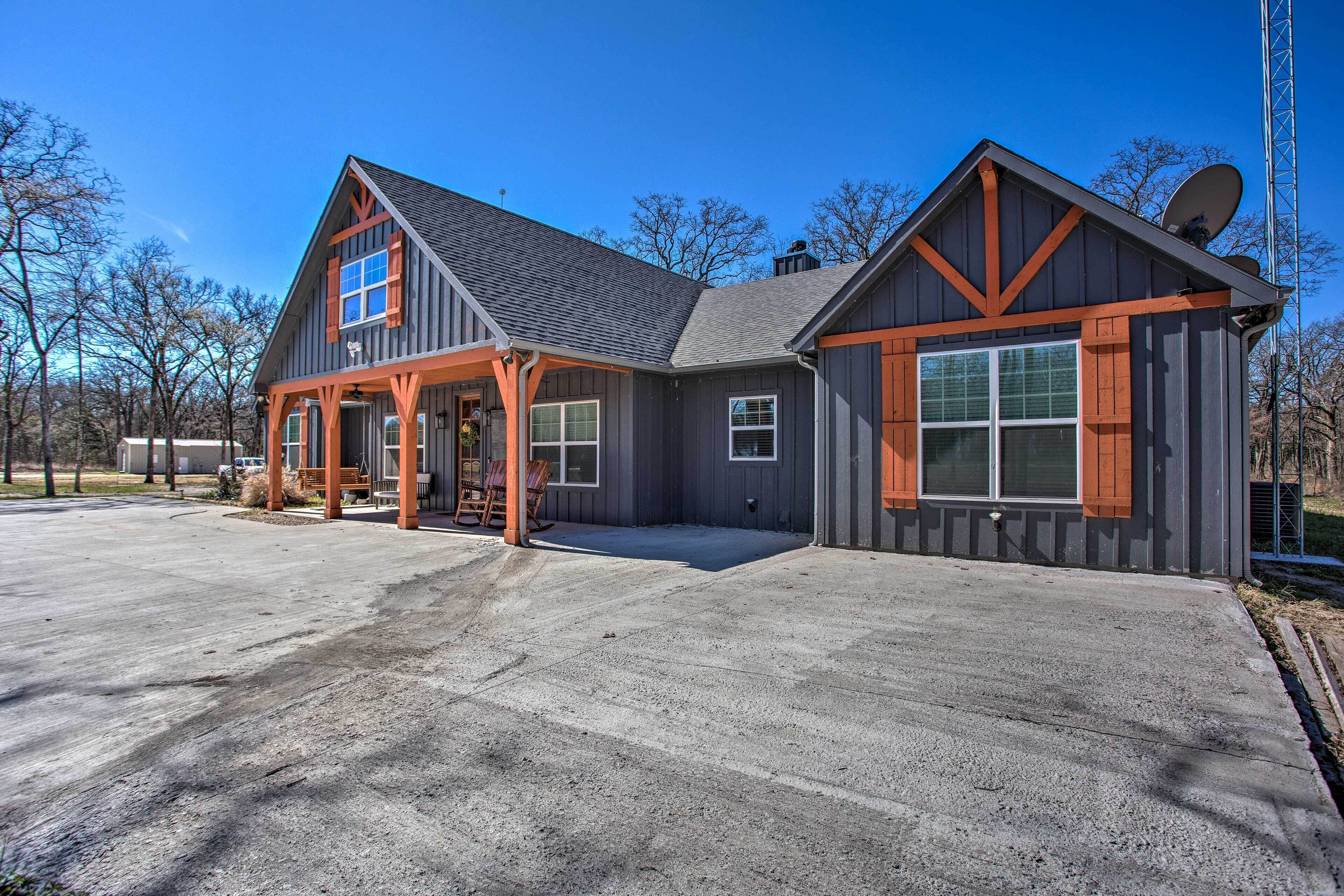 A two-story house with a large front porch, a satellite dish, and a garage.