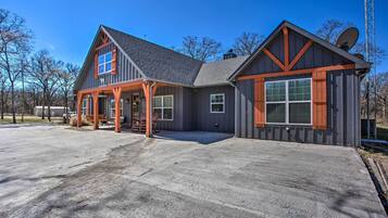 A two-story house with a large front porch, a satellite dish, and a garage.