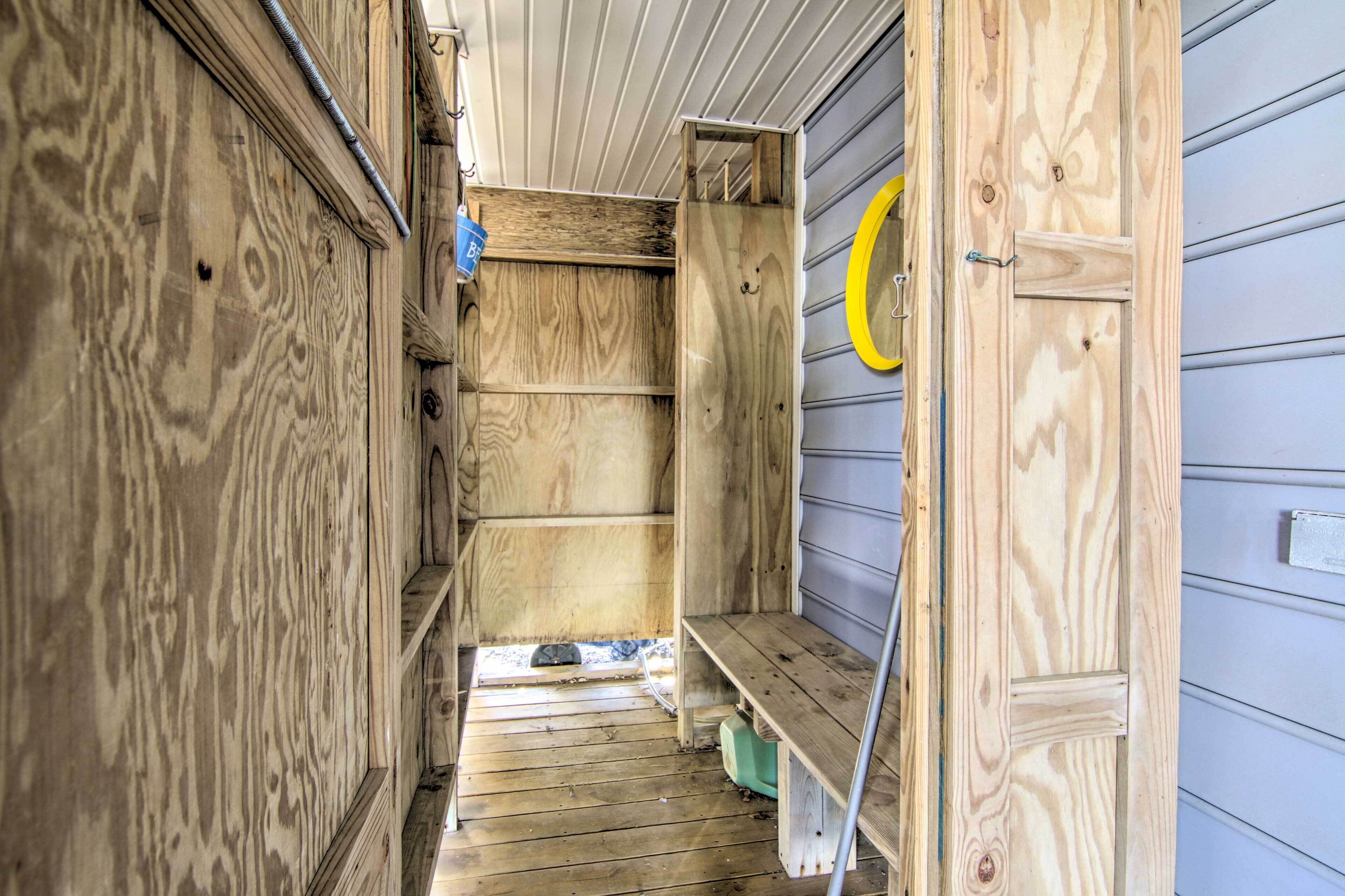 Un estrecho pasillo de madera con un banco y una puerta de pomo amarillo.