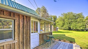 Une maison en bois avec un porche couvert, une fenêtre et une porte.