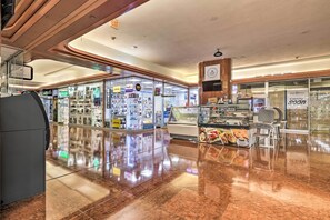 Un interior limpio y moderno con piso pulido, vitrinas de vidrio y una variedad de tiendas.