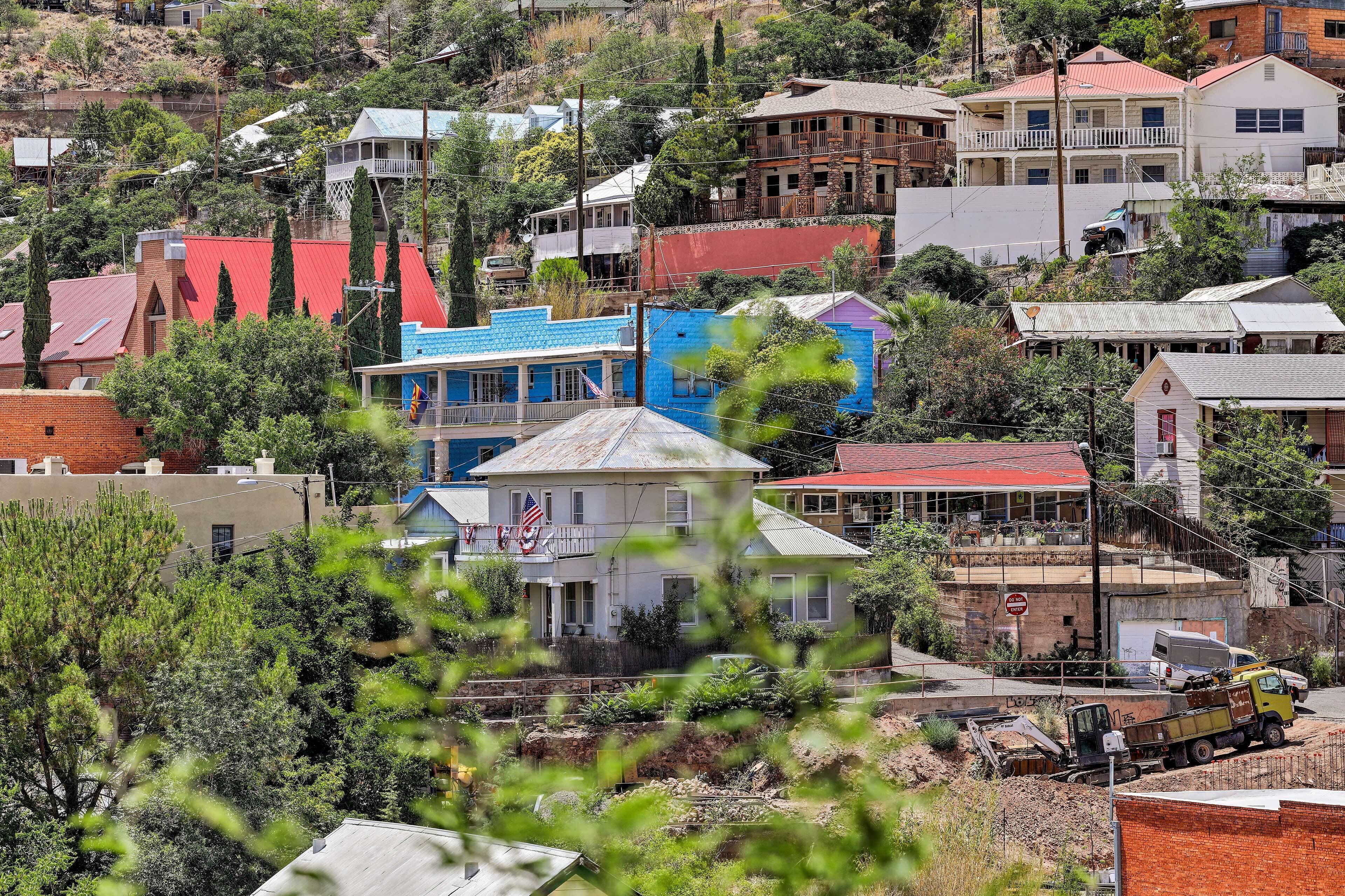 A residential area with houses of various architectural styles, including a prominent white house with a red roof and a blue house with a white roof.