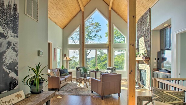 A spacious living area with a high ceiling, large windows, and a fireplace. - Grand Chalet w/ Hot Tub - Near Wintergreen Resort (Nellysford)