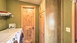 A laundry room with a washing machine, wooden cabinets, and a door. - Lakefront Eatonville Cabin w/ Dock & Mtn Views! (Eatonville)