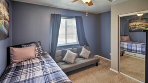 A bedroom with a bed, a sofa, a ceiling fan, and a window with curtains. - Lake Havasu City Retreat w/ Patio & Grill (Lake Havasu City)