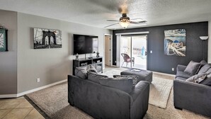 A living room with a gray sofa, a TV, and artwork on the walls. - Lake Havasu City Retreat w/ Patio & Grill (Lake Havasu City)