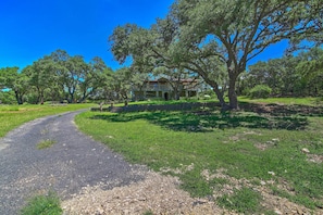 A house surrounded by trees with a gravel driveway. - Countryside Cottage: 17 Mi to Downtown San Antonio (San Antonio)