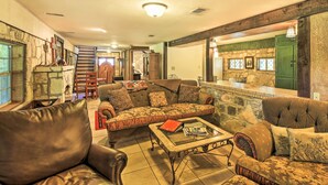 A cozy living room with a sectional sofa, a coffee table, and a fireplace. - Countryside Cottage: 17 Mi to Downtown San Antonio (San Antonio)