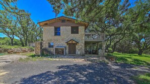 A stone house with a porch, surrounded by trees. - Countryside Cottage: 17 Mi to Downtown San Antonio (San Antonio)