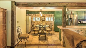 A dining area with a stone wall, green cabinets, and a modern refrigerator. - Countryside Cottage: 17 Mi to Downtown San Antonio (San Antonio)