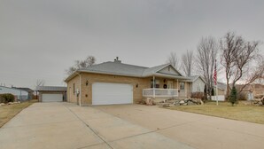 A single-story house with a garage, a front porch, and a small front yard. - Farr West Apartment on Farm < 25 Mi to Ski Resorts (Ogden)