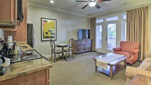 A living room with a TV, a fireplace, a dining table, and a sofa. - Anderson Creek Club Condo w/ Community Amenities! (Spring Lake)