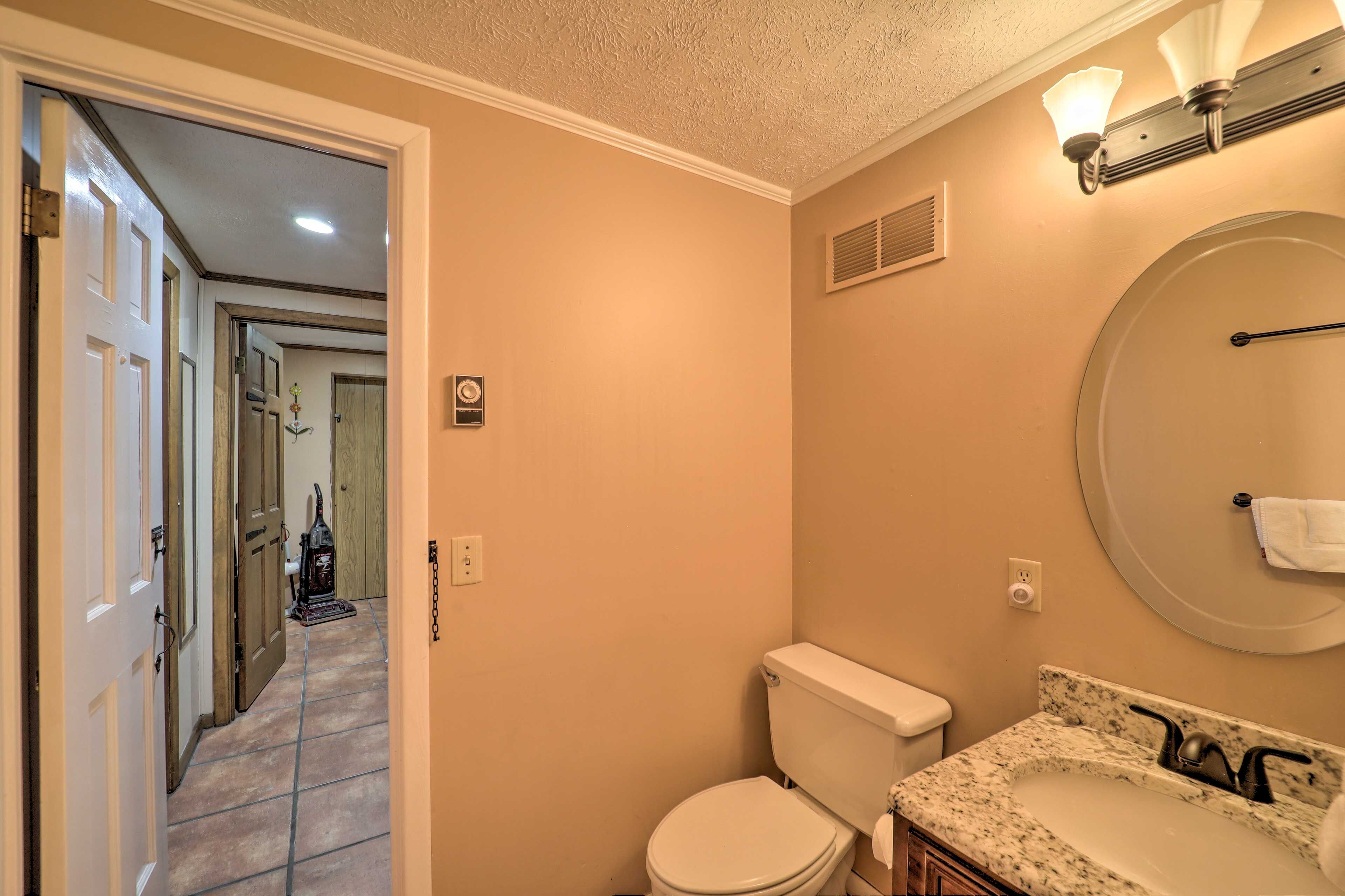 A bathroom with a toilet, sink, and vanity.