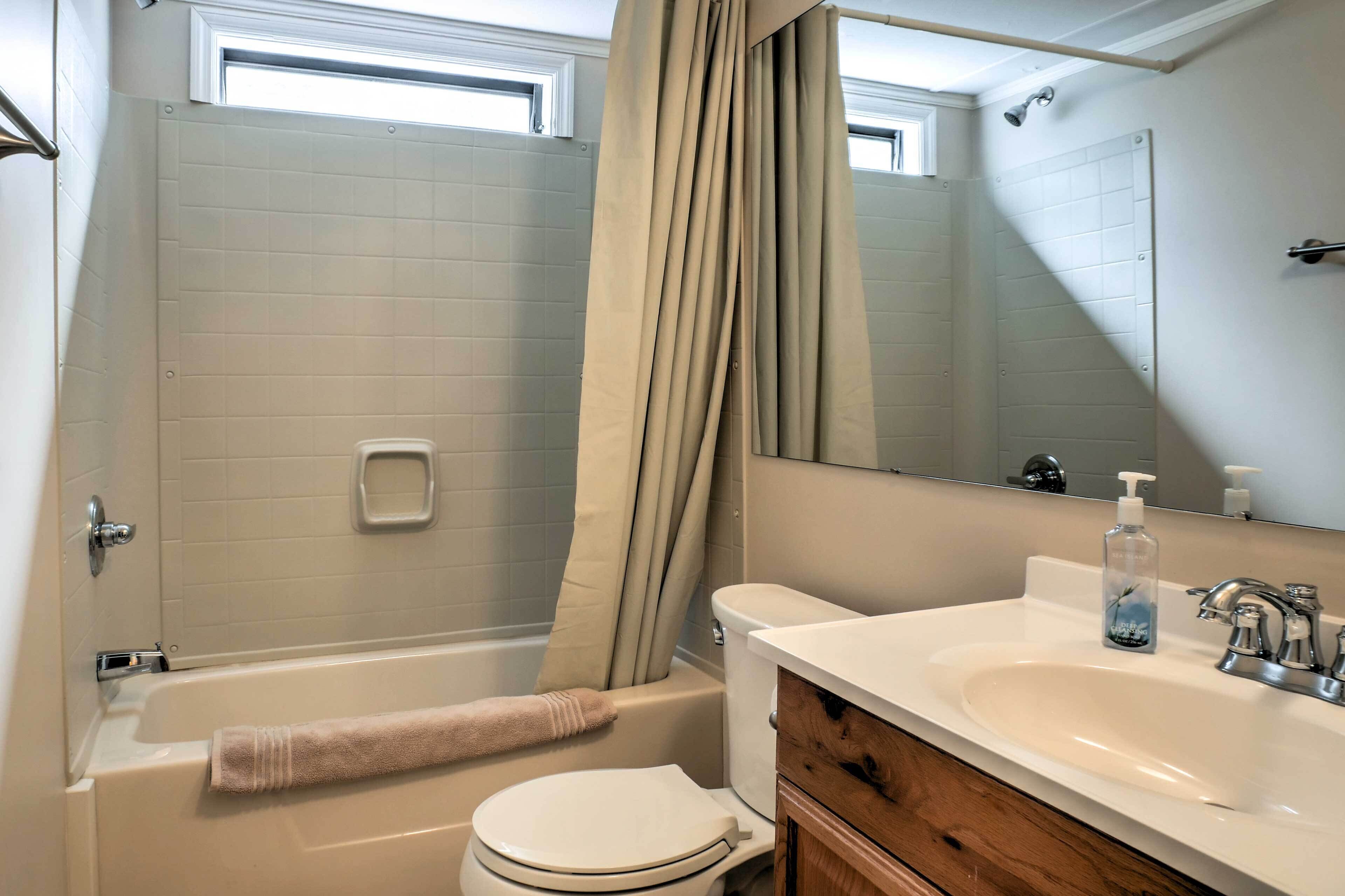 A bathroom with a bathtub, toilet, and sink.