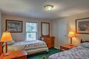 A bedroom with two beds, a dresser, a mirror, and two lamps. - Ooltewah Cabin w/ Grill, Pool Table & Porch! (Ooltewah)