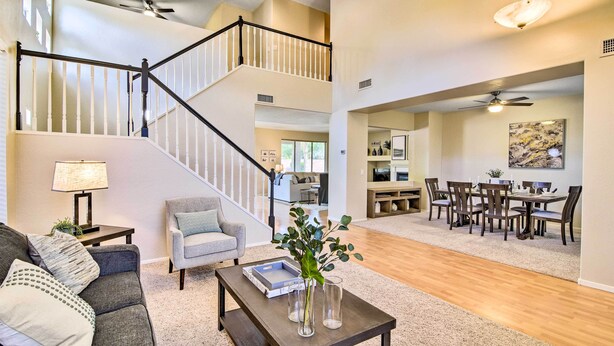 A spacious living room with a staircase, a dining area, and a kitchen.