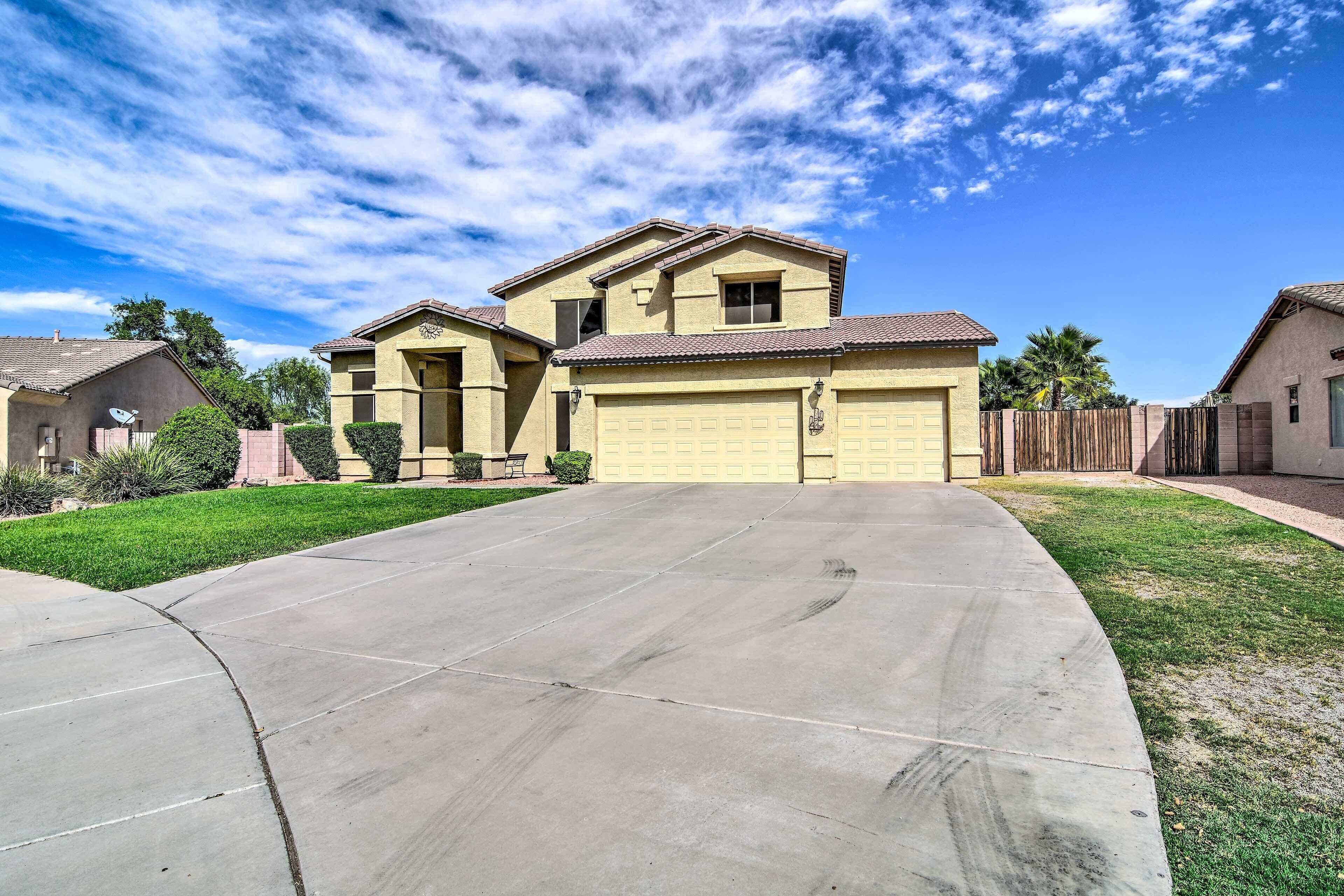 A residential house with a garage, a driveway, and a well-maintained lawn.