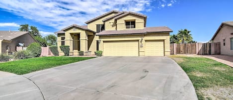 A residential house with a garage, a driveway, and a well-maintained lawn.