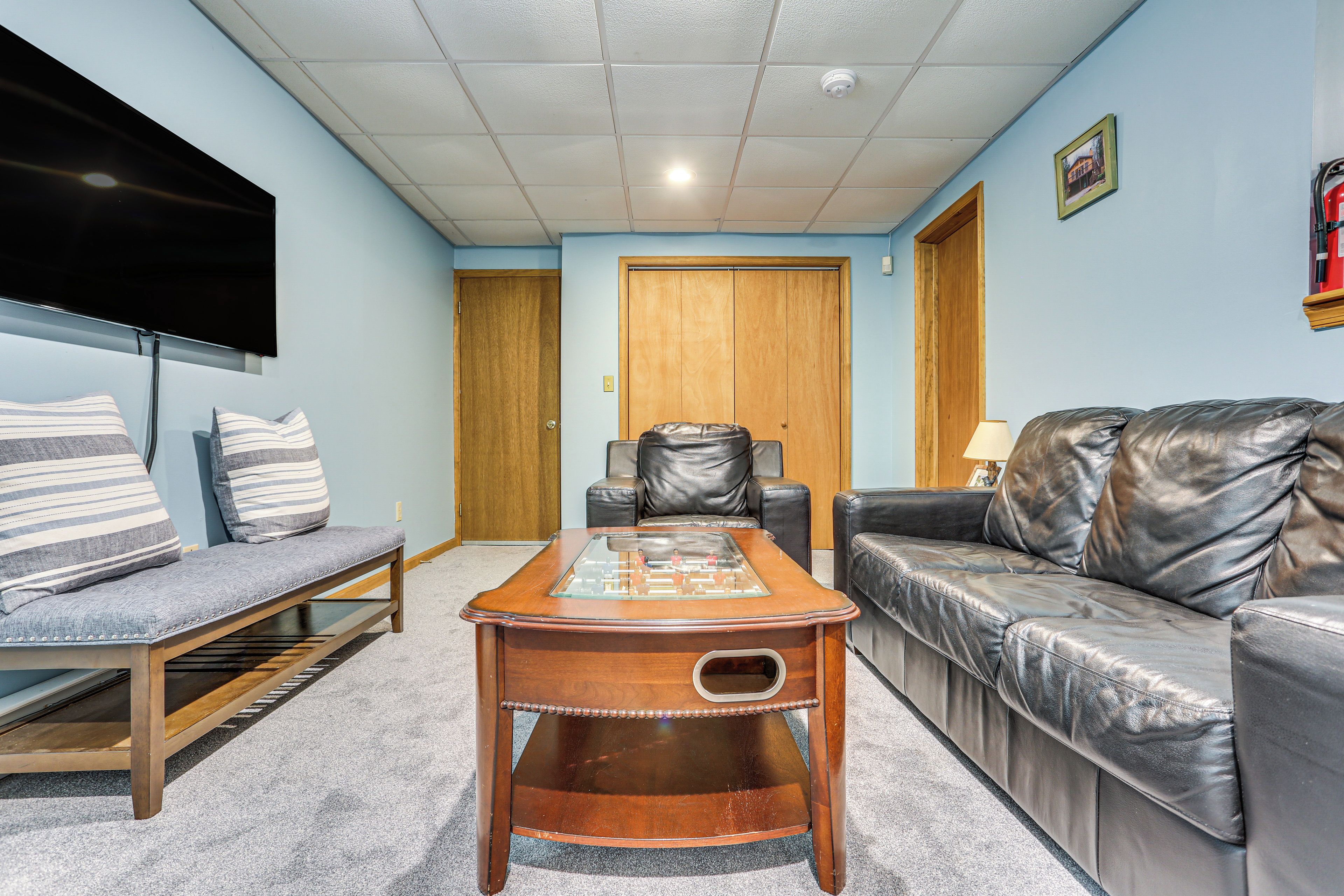 Una sala de estar con un sofá, un banco, una mesa de centro y un televisor.