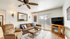 A living room with a ceiling fan, a television, a sofa, and a coffee table. - Walk to Trails! Sedona Casita w/ Fire Pit & Views (Sedona)