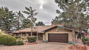 A residential house with a brick driveway, a garage, and a well-maintained garden with various shrubs and trees. - Walk to Trails! Sedona Casita w/ Fire Pit & Views (Sedona)