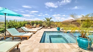 Una piscina con sillones de descanso y una planta en maceta.