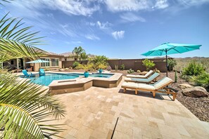 A backyard with a swimming pool, lounge chairs, and a patio area. - Resort-style Pool & Spa: Upscale Goodyear Home (Goodyear)