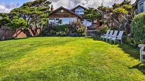 Un jardin avec une maison en bois, une pelouse et un espace barbecue.