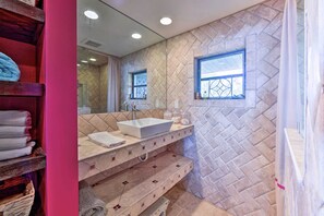 A bathroom with a large mirror, a white sink, and a herringbone-patterned wall. - 'the Bougainvilla' w/ Boat Slip on Lake Istokpoga! (Lorida)