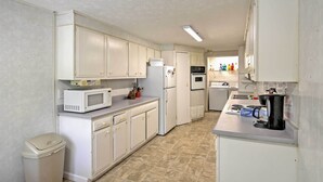 A compact kitchen with white cabinets, a microwave, a refrigerator, a sink, and a coffee maker. - Jasonville Cabin - Walk to Shakamak State Park! (Jasonville)