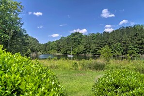 A serene lakeside view with dense forest and a small boat on the water. - Near Beaches: Ocean View Condo w/ Balcony! (Ocean View)