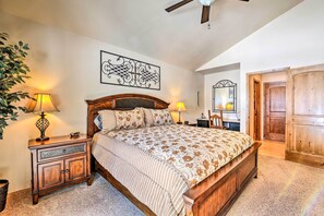 A bedroom with a wooden bed, two bedside tables with lamps, a large mirror, and a door to another room. - Steps to Golf Course: Condo w/ Grill in Pinetop! (Pinetop)