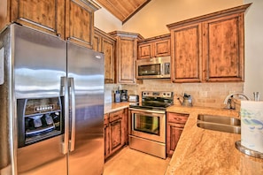 A kitchen with wooden cabinets, stainless steel appliances, granite countertops, and a built-in oven. - Steps to Golf Course: Condo w/ Grill in Pinetop! (Pinetop)