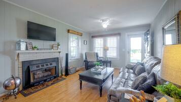A living room with a fireplace, a television mounted on the wall, a sofa, and a coffee table.