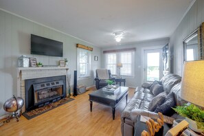 A living room with a fireplace, a television mounted on the wall, a sofa, and a coffee table.