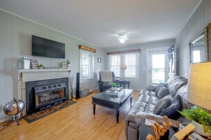 A living room with a fireplace, a television mounted on the wall, a sofa, and a coffee table.