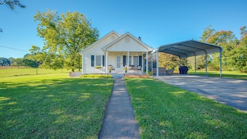 A two-story house with a covered porch and a lawn.