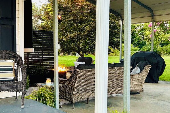An outdoor patio with wicker furniture, a fire feature, and a covered area. - Peaceful Elkin Vacation Rental ~ 17 Mi to Mt Airy! (Elkin)